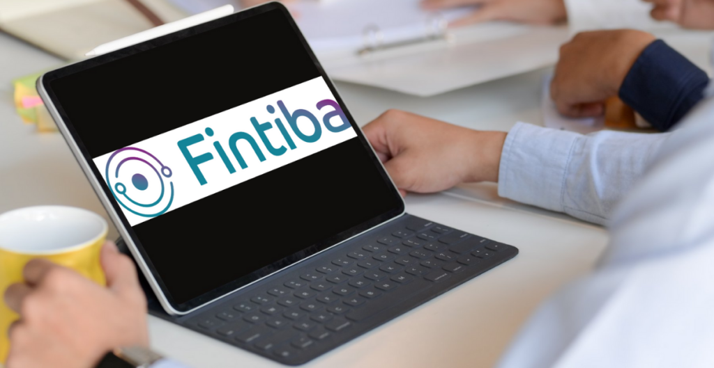 رجل يجلس أمام طاولة عليها تاب يعرض شعار منصة Fintiba من أجل فتح الحساب البنكي المغلق والتأمين الصحي